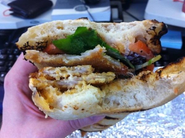 Biting into a Schnitzel & Things sandwich.